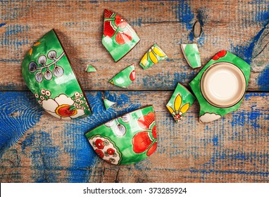 Broken Ceramic Plate On Wooden Table