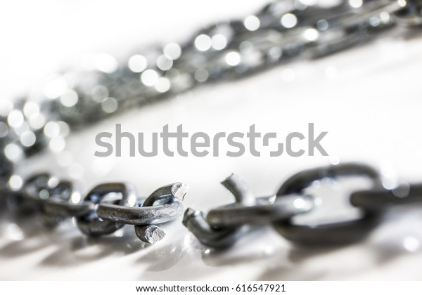 Broken chain on white surface, selective focus\
shallow depth of field