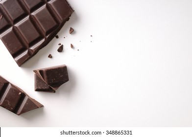 Broken chocolate bar left position isolated on white table. Horizontal composition. Top view