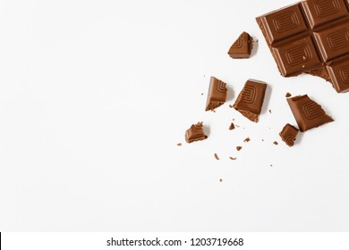 Broken chocolate bar, white background, top view