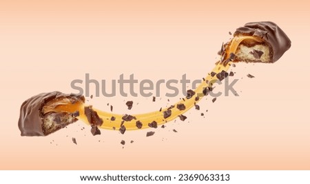 Broken chocolate bar with yummy caramel in air on pale coral background, banner design