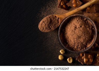 Broken Chocolate Nuts Pieces And Cocoa Powder On Dark Background
