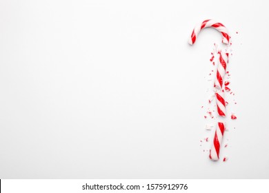 Broken Christmas candy canes on white background. Minimal composition with peppermint candies. Top view - Powered by Shutterstock