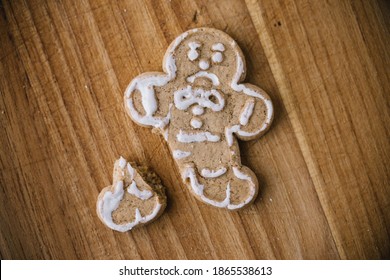 Broken Christmas Gingerbread Man Cookie On Wooden Board