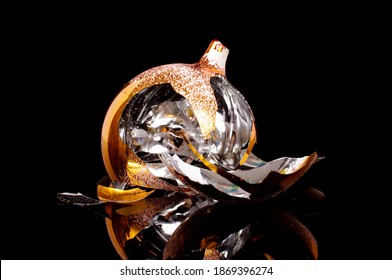 Broken Christmas Tree Decoration Ball Isolated On The Black Reflective Background