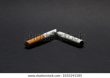 broken cigarette on a black background, quit smoking