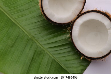 broken coconut with banana leaf