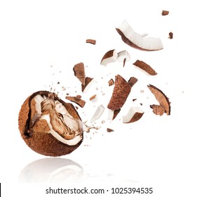 Broken coconut with splashes of juice close-up, isolated on white background 