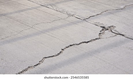 Broken crack lines texture on the old damaged concrete street surface