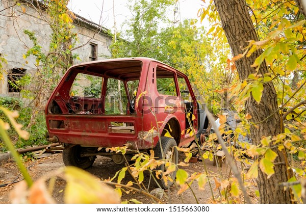 Broken, crumpled, dented car. Abandoned\
wrecked cars. Dump of wrecked cars. Autumn\
background