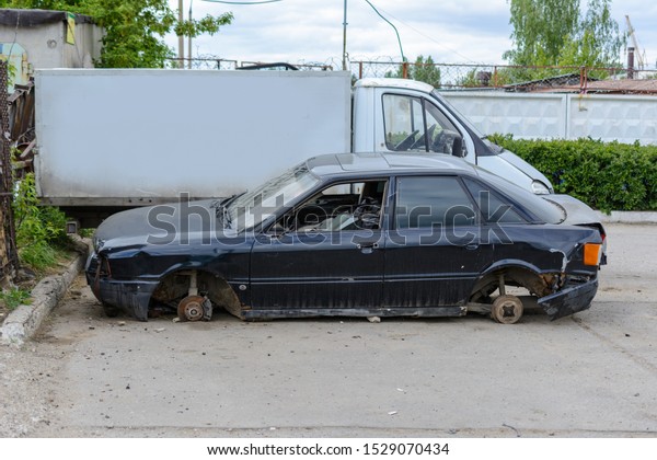 Broken, crumpled, dented car after the\
accident. Abandoned wrecked cars. Dump of wrecked cars. Broken auto\
after an accident.