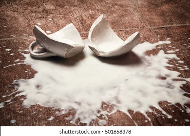 A broken cup and spilled yogurt on the floor - Shutterstock ID 501658378