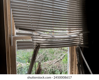 Broken curtain, shade shutters, jalousie or Venetian blinds on window of an abandoned house or home. abandoned old building concept. old damaged window blinds in a room of dirty house. home interior - Powered by Shutterstock