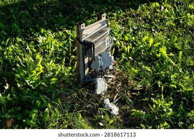 Broken and damaged outdoor electrical control box on grass
