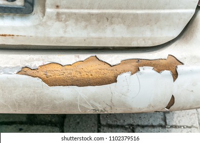 Broken And Damaged Rear Bumper On The Dirty White Car Close Up