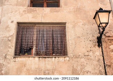 Broken And Damaged Window Next To Vintage Streetlight In An Old House In Spain