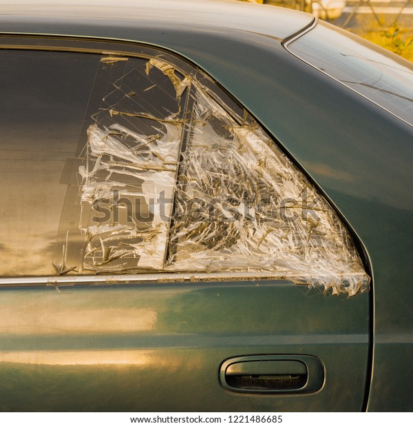 broken dark\
car rear window sealed with scotch\
tape