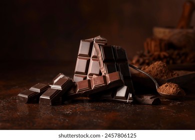 Broken dark chocolate bar and cocoa powder on a brown table. Copy space. - Powered by Shutterstock