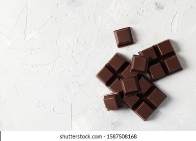 Broken Dark Chocolate Pieces On A Light Background. View From Above. Top View.