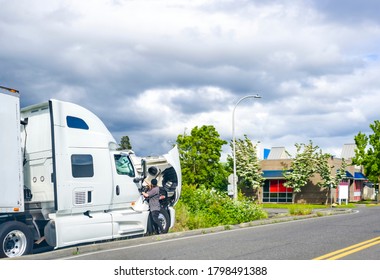 Broken Day Cab Industrial Big Rig White Semi Truck Tractor For Heavy-duty Freights Standing With Open Hood On The Road Waiting For A Mobile Repair Team And A Towing Truck To Tow To A Repair Shop