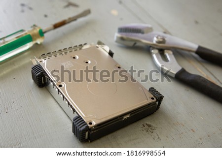 Broken and Destroyed Hard Drive Disk and Tools on Wooden Table