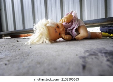 Broken doll among rubble, war childhood destroyed