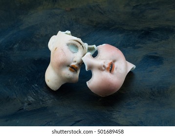 Broken Doll Face Parts Isolated On Grunge Grey And Black Background