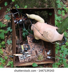 Broken Doll In An Old Computer Housing In The Woods