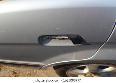 A Broken Door Handle On Gray Car.