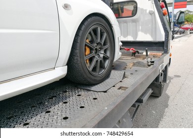 Broken Down Auto Vehicle Car Towed Onto Flatbed Tow Truck With Hook And Chain