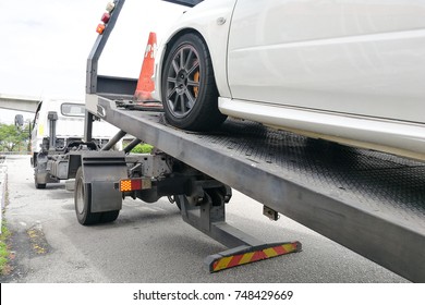 Broken Down Auto Vehicle Car Towed Onto Flatbed Tow Truck With Hook And Chain