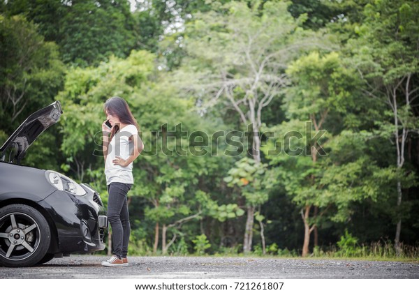 Broken\
down car and asian woman calling car mechanic\
\
