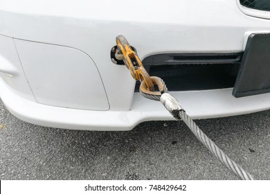 Broken Down Car Fitted With Hook And Chain Being Towed By Tow Truck