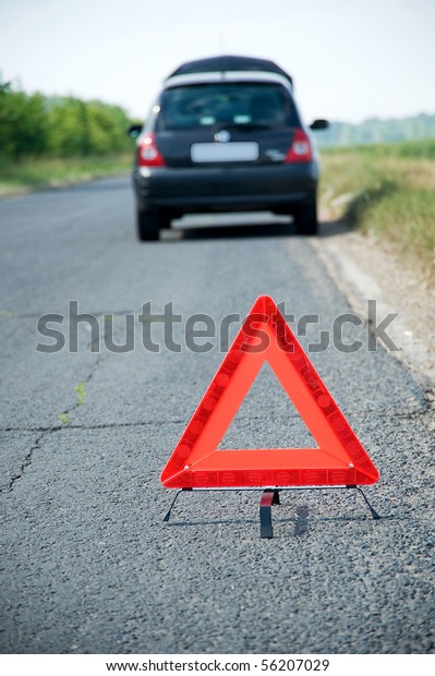 Broken down car with\
red warning triangle