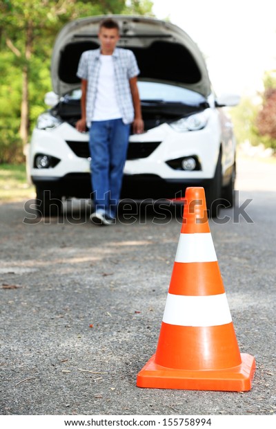 Broken down car with warning\
cone