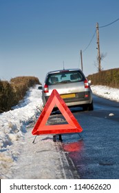 Broken Down Motor Vehicle With Red Warning Triangle In Winter Snow Conditions