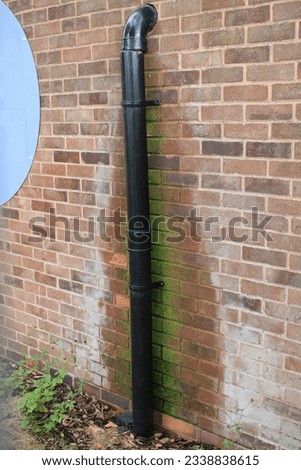 Broken Drain pipe disconnected from down pipe and leaking water down brick wall, damp wall
