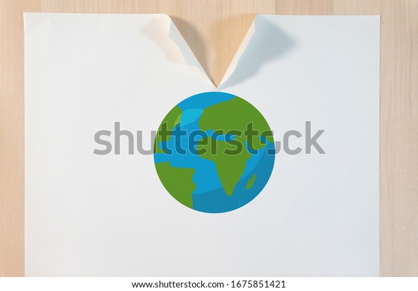 Broken Earth on a tearing paper on the table\
with global risk disaster concept\
