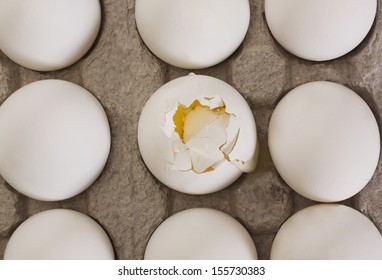 Broken Egg In A Carton With Other Eggs