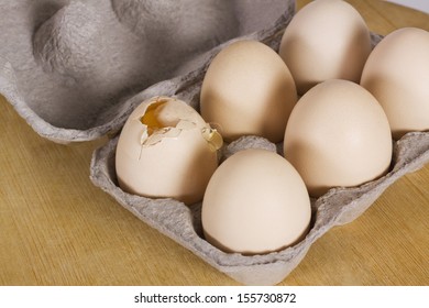 Broken Egg In A Carton With Other Eggs