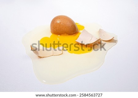 Broken egg falls, white background.