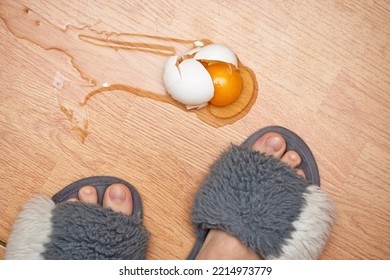 broken egg and feet on the floor in kitchen
