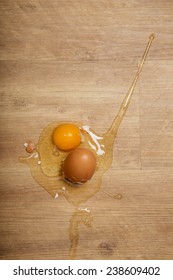 Broken Egg On Wooden Floor