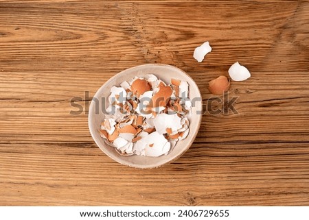 Broken Egg Shell in Bowl, Crushed Eggshell, Calcium Supplement, Cracked Eggshells, Natural Compost Ingredient, Broken Egg Shells on Wood Table Background Top View