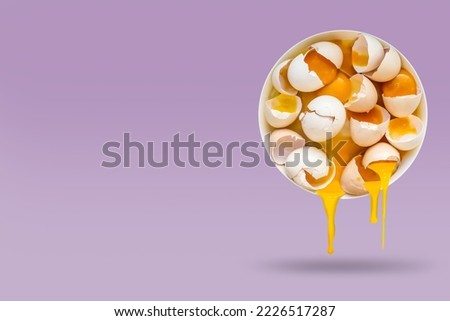 Broken eggs in a round plate fall into the air, isolated on a lilac background, with space for text. Food levitation, weightlessness concept, weightlessness.