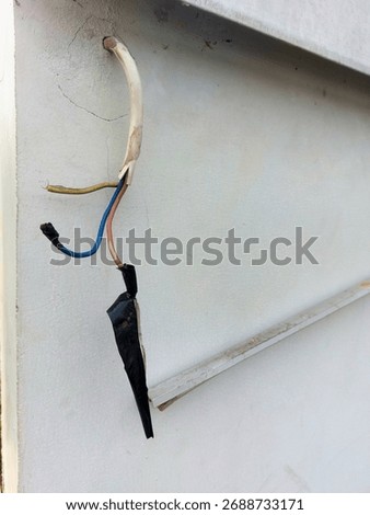 broken electrical cable installations, hanging from the white walls.