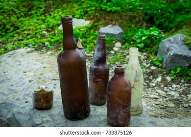 Broken and empty bottles, on top of a slab of rock