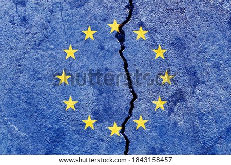Broken EU (European Union) flag isolated on cracked wall background, abstract Europe politics economy conflicts concept
