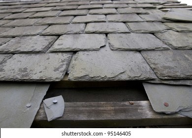 broken and fallen slate leaves hole in a roof due to storm or decay