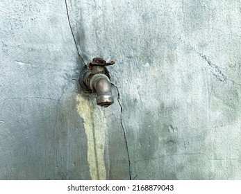 Broken Faucet On Cracked Wall